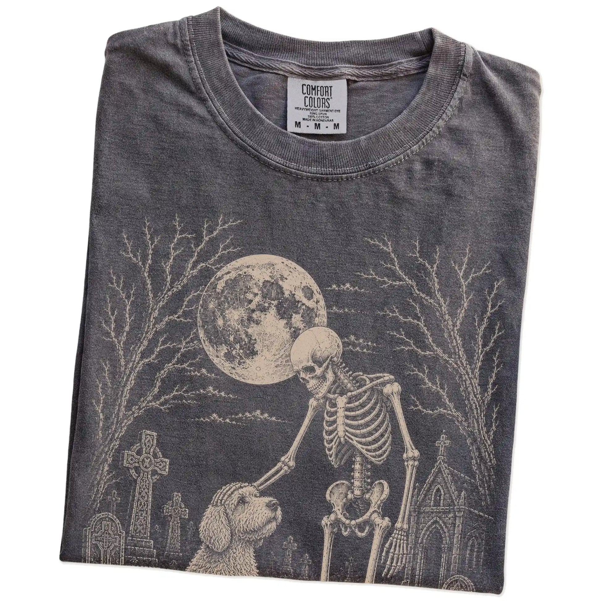 Folded Pepper Comfort Colors® T-shirt showing Labradoodle sharing a quiet cemetery moment with a friendly skeleton