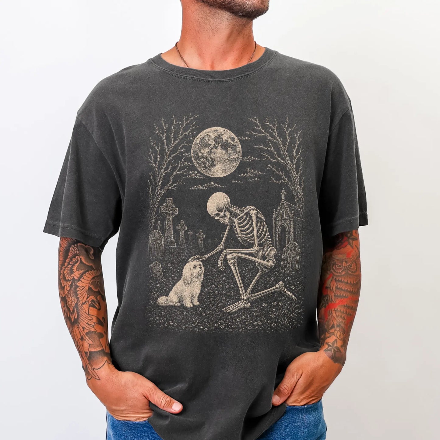 Model wearing a Pepper Comfort Colors® T-shirt showing Maltese sharing a quiet cemetery moment with a friendly skeleton
