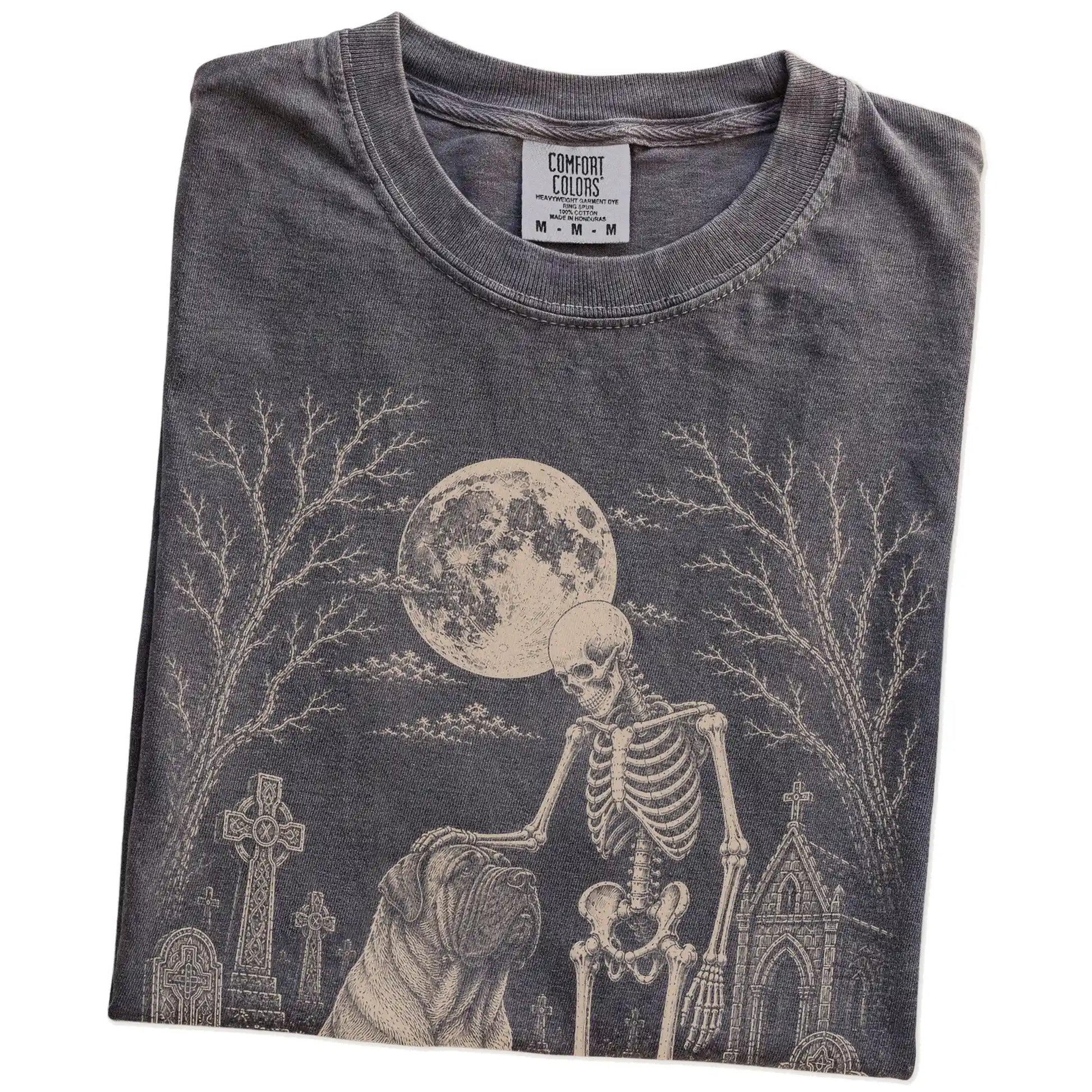 Folded Pepper Comfort Colors® T-shirt showing Mastiff sharing a quiet cemetery moment with a friendly skeleton