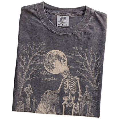 Folded Pepper Comfort Colors® T-shirt showing Mastiff sharing a quiet cemetery moment with a friendly skeleton
