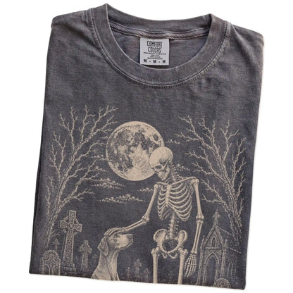 Folded Pepper Comfort Colors® T-shirt showing Pointer sharing a quiet cemetery moment with a friendly skeleton
