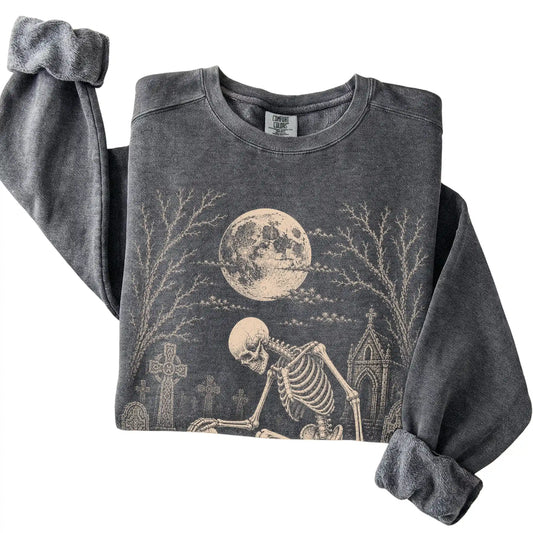 Folded Pepper sweatshirt with a skeleton petting a Poodle in a graveyard