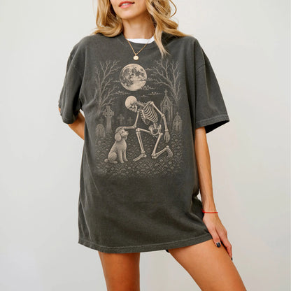 Model wearing a Pepper Comfort Colors® T-shirt showing Poodle sharing a quiet cemetery moment with a friendly skeleton