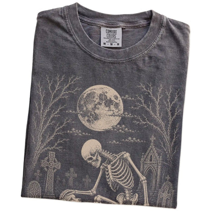 Folded Pepper Comfort Colors® T-shirt showing Poodle sharing a quiet cemetery moment with a friendly skeleton