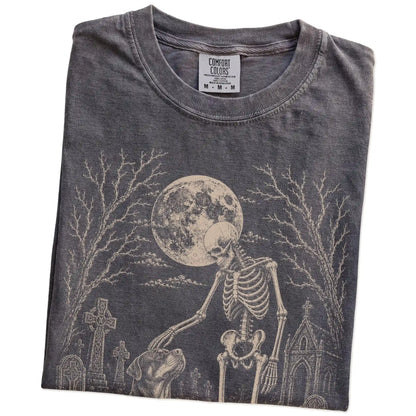 Folded Pepper Comfort Colors® T-shirt showing Rottweiler sharing a quiet cemetery moment with a friendly skeleton