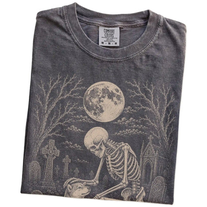 Folded Pepper Comfort Colors® T-shirt showing Shiba Inu sharing a quiet cemetery moment with a friendly skeleton