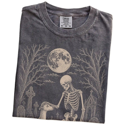 Folded Pepper Comfort Colors® T-shirt showing Whippet sharing a quiet cemetery moment with a friendly skeleton