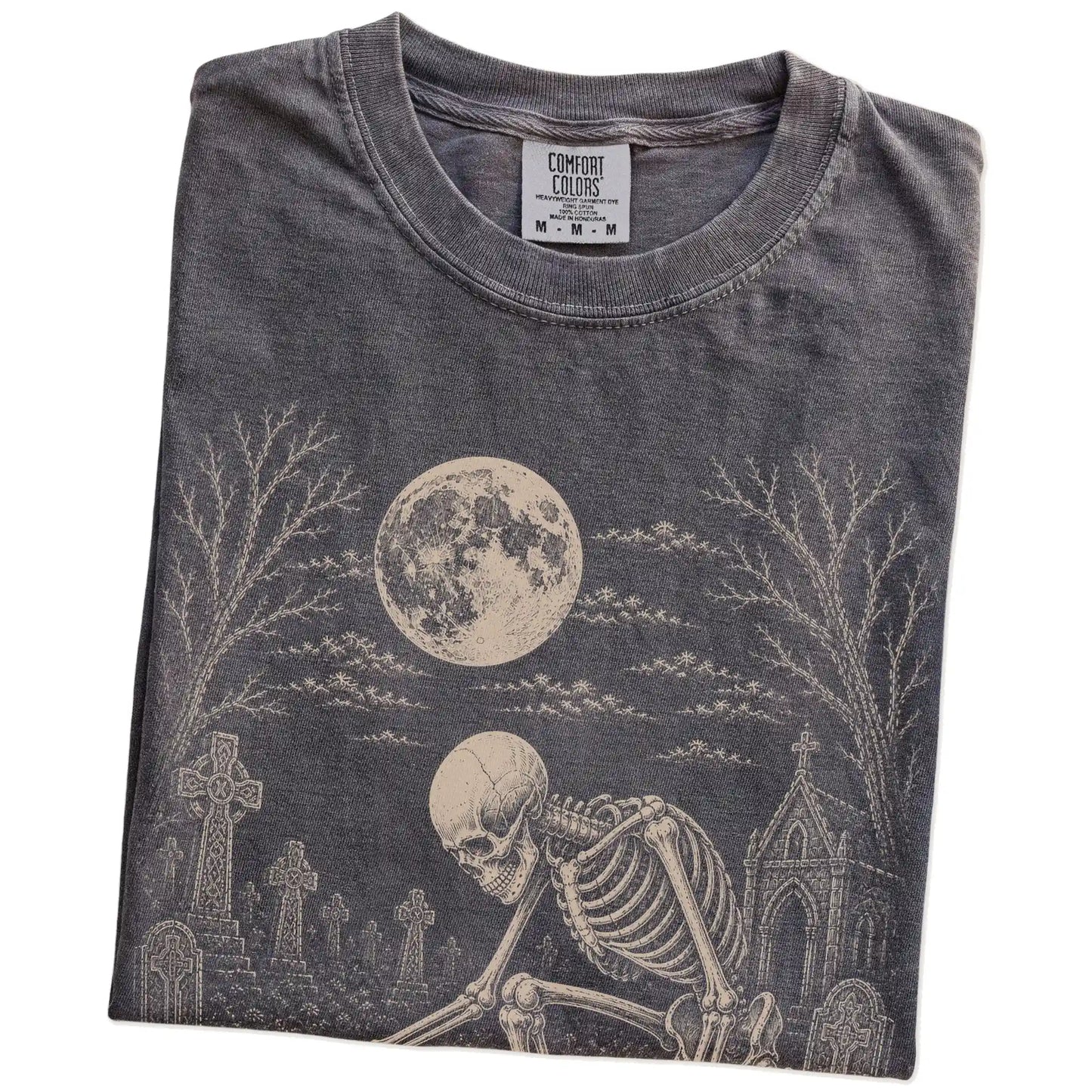 Folded Pepper Comfort Colors® T-shirt showing Yorkie sharing a quiet cemetery moment with a friendly skeleton