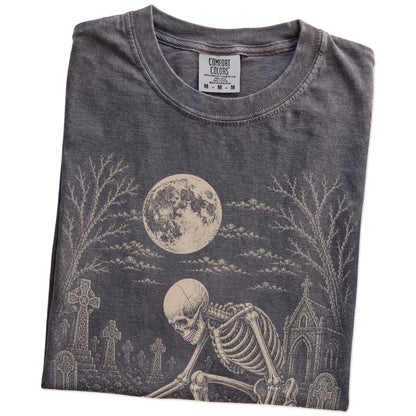 Folded Pepper Comfort Colors® T-shirt showing Yorkie sharing a quiet cemetery moment with a friendly skeleton