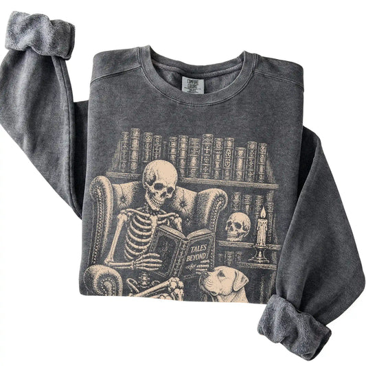 Folded Pepper sweatshirt with a skeleton reading Tales Beyond to an American Bulldog