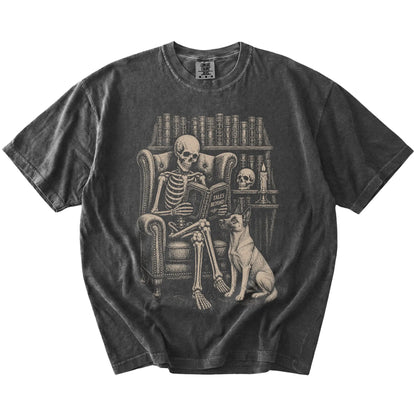 Skeleton reading in a library beside a Belgian Malinois on a Pepper Comfort Colors® T-shirt