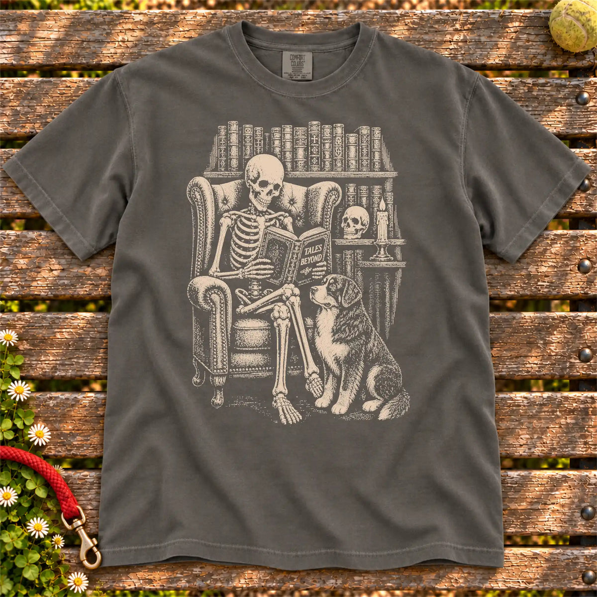 Skeleton reading in a library beside a Bernese Mountain Dog on a Pepper Comfort Colors® T-shirt