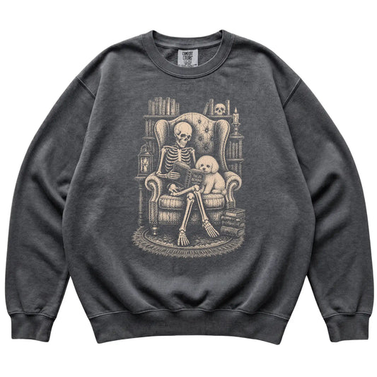 Skeleton reading Tales Beyond to a Bichon Frise on a Pepper sweatshirt