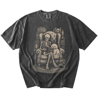 Skeleton reading in a library beside a Bichon Frise on a Pepper Comfort Colors® T-shirt