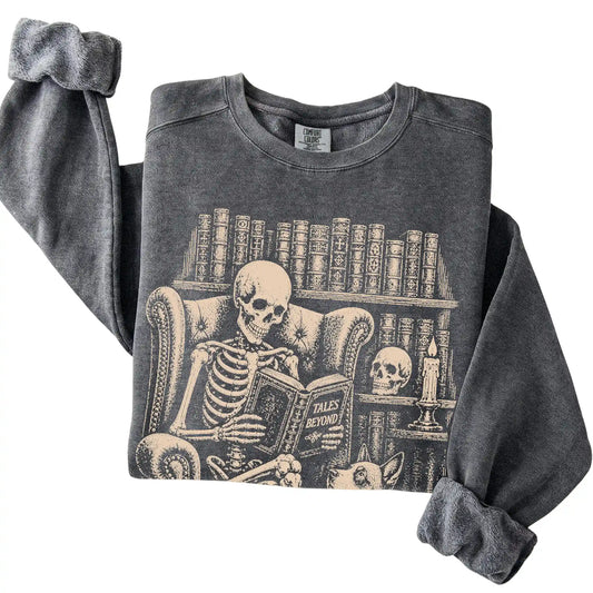 Folded Pepper sweatshirt with a skeleton reading Tales Beyond to a Blue Heeler