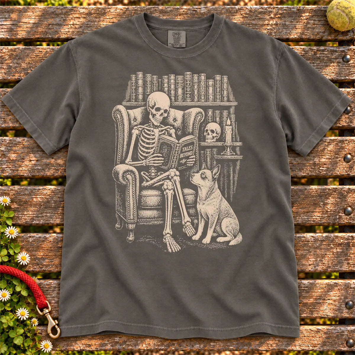 Skeleton reading in a library beside a Blue Heeler on a Pepper Comfort Colors® T-shirt
