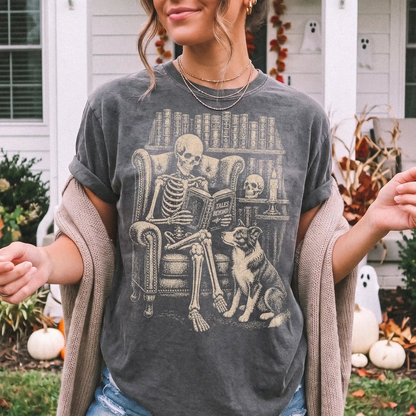 Model wearing a Pepper Comfort Colors® T-shirt showing skeleton reading in a library beside a Border Collie