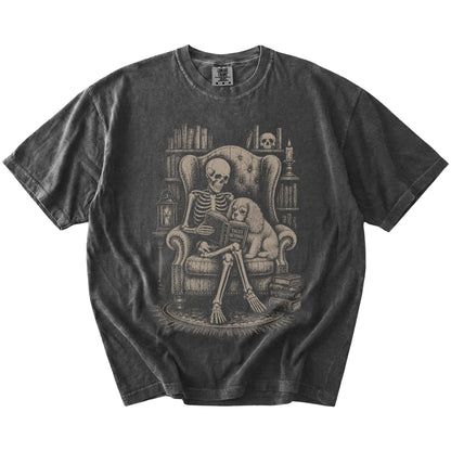 Skeleton reading in a library beside a Cavalier King Charles Spaniel on a Pepper Comfort Colors® T-shirt