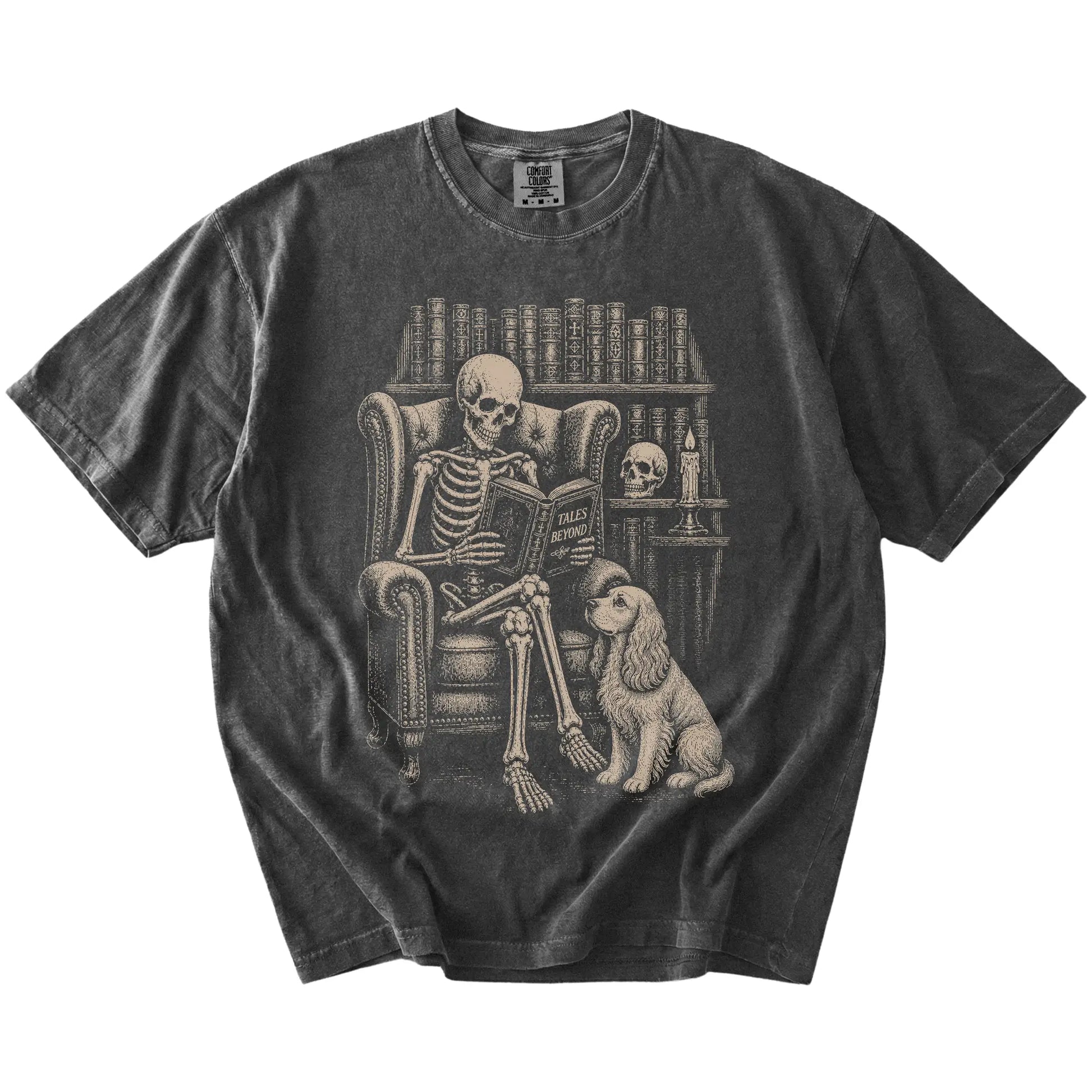 Skeleton reading in a library beside a Cocker Spaniel on a Pepper Comfort Colors® T-shirt