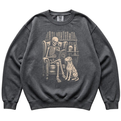 Skeleton reading Tales Beyond to a Dalmatian on a Pepper sweatshirt