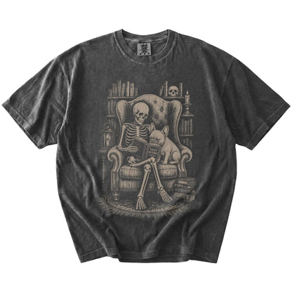 Skeleton reading in a library beside a French Bulldog on a Pepper Comfort Colors® T-shirt