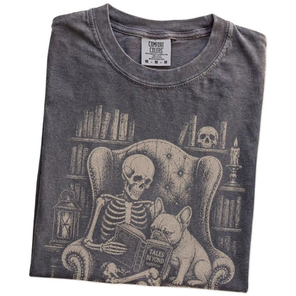 Folded Pepper Comfort Colors® T-shirt showing skeleton reading in a library beside a French Bulldog