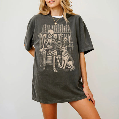 Model wearing a Pepper Comfort Colors® T-shirt showing skeleton reading in a library beside a German Shepherd