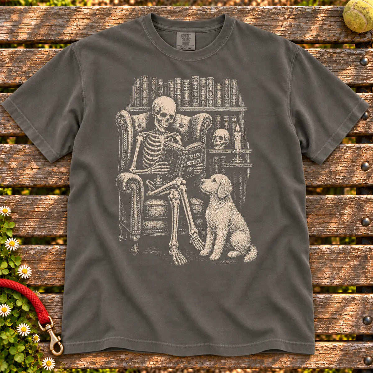 Skeleton reading in a library beside a Goldendoodle on a Pepper Comfort Colors® T-shirt