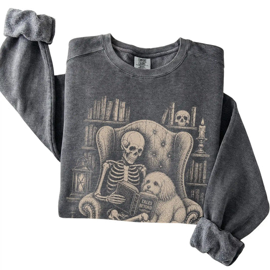 Folded Pepper sweatshirt with a skeleton reading Tales Beyond to a Havanese