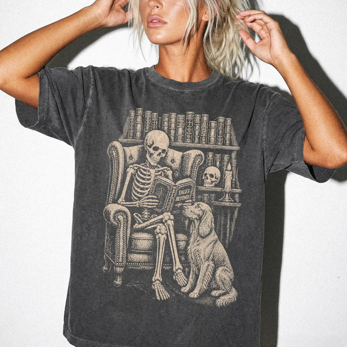 Model wearing a Pepper Comfort Colors® T-shirt showing skeleton reading in a library beside a Irish Setter