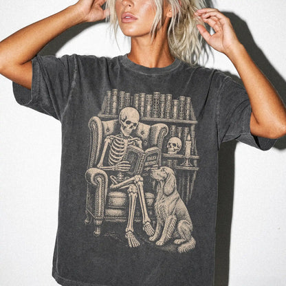 Model wearing a Pepper Comfort Colors® T-shirt showing skeleton reading in a library beside a Irish Setter