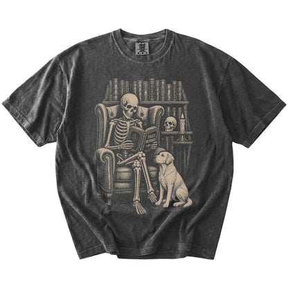 Skeleton reading in a library beside a Labrador Retriever on a Pepper Comfort Colors® T-shirt