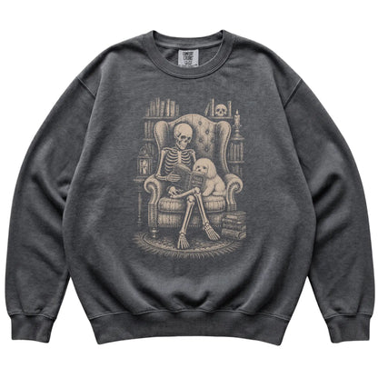 Skeleton reading Tales Beyond to a Maltese on a Pepper sweatshirt
