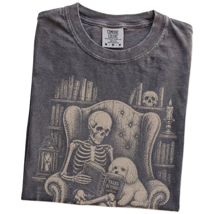 Folded Pepper Comfort Colors® T-shirt showing skeleton reading in a library beside a Maltese