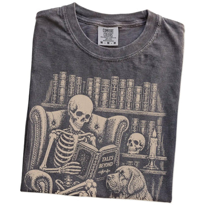 Folded Pepper Comfort Colors® T-shirt showing skeleton reading in a library beside a Newfie