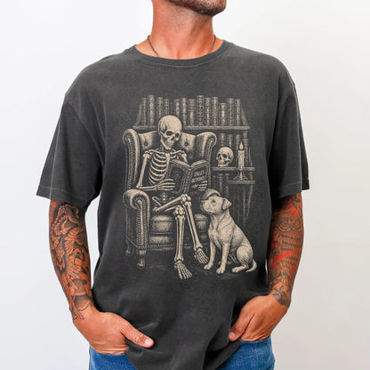 Model wearing a Pepper Comfort Colors® T-shirt showing skeleton reading in a library beside a Pitbull