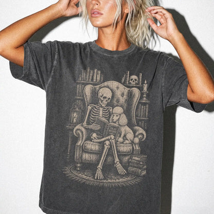 Model wearing a Pepper Comfort Colors® T-shirt showing skeleton reading in a library beside a Poodle
