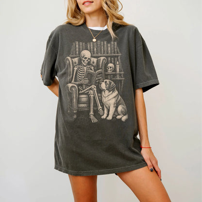 Model wearing a Pepper Comfort Colors® T-shirt showing skeleton reading in a library beside a Saint Bernard