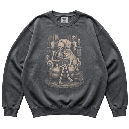 Skeleton reading Tales Beyond to a Shiba Inu on a Pepper sweatshirt