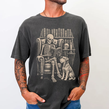 Model wearing a Pepper Comfort Colors® T-shirt showing skeleton reading in a library beside a Schnauzer
