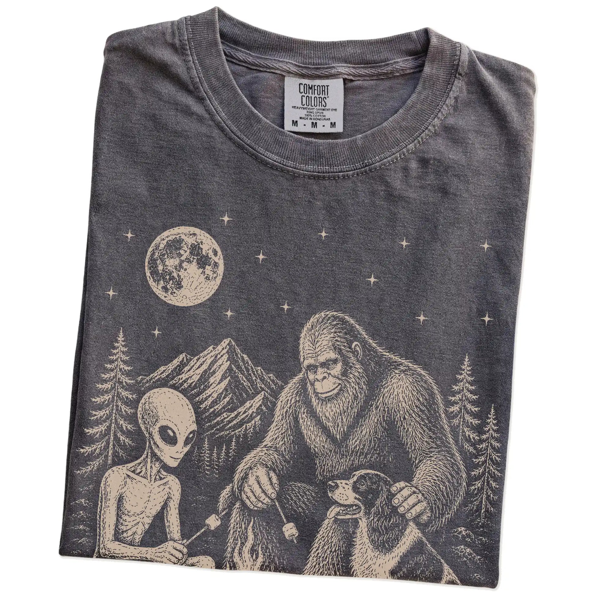 Folded Pepper Comfort Colors® T-shirt showing Springer Spaniel camping with Bigfoot and an alien