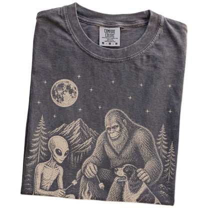 Folded Pepper Comfort Colors® T-shirt showing Springer Spaniel camping with Bigfoot and an alien