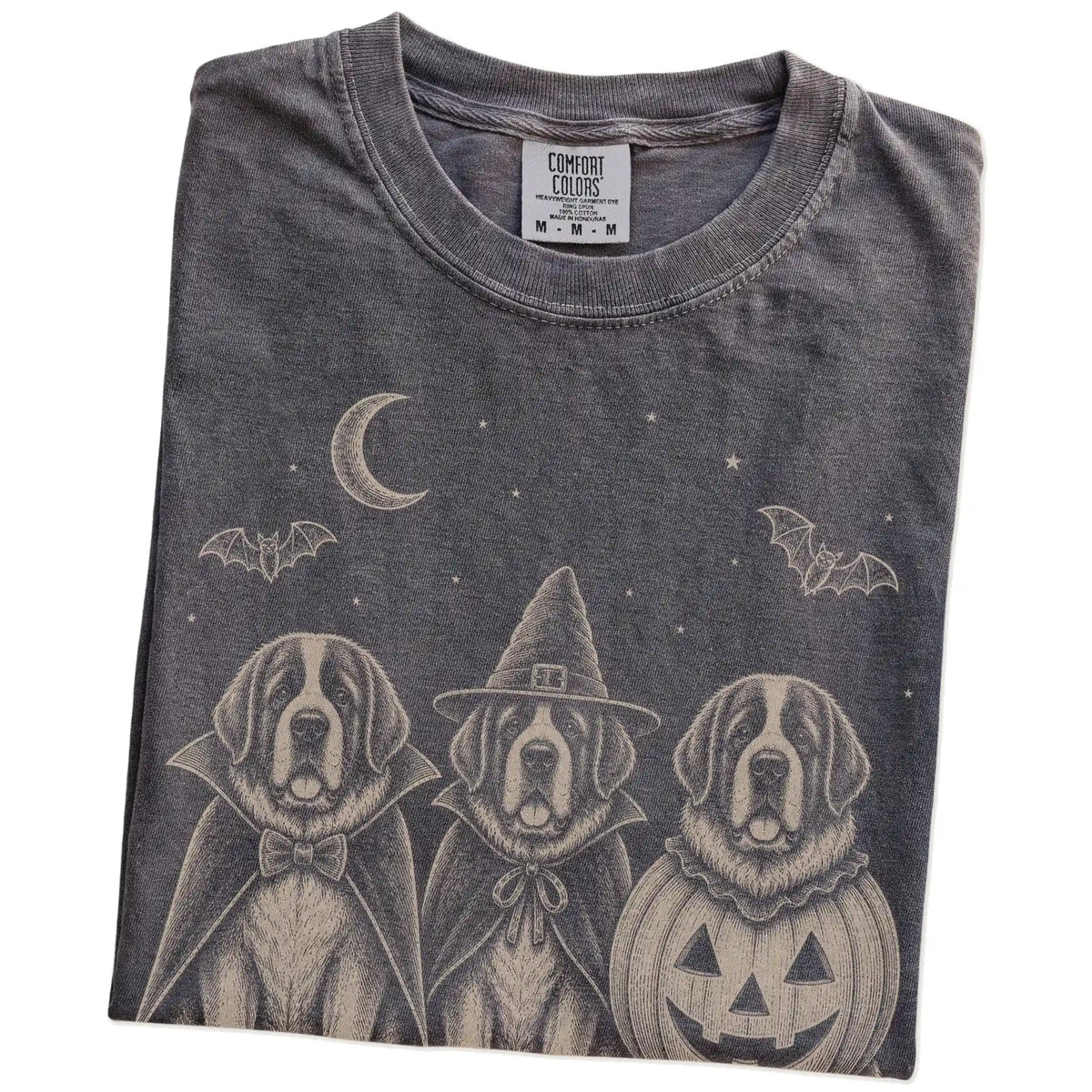 Folded Pepper Comfort Colors® T-shirt showing three St Bernard dogs dressed for Halloween beneath bats and a crescent moon