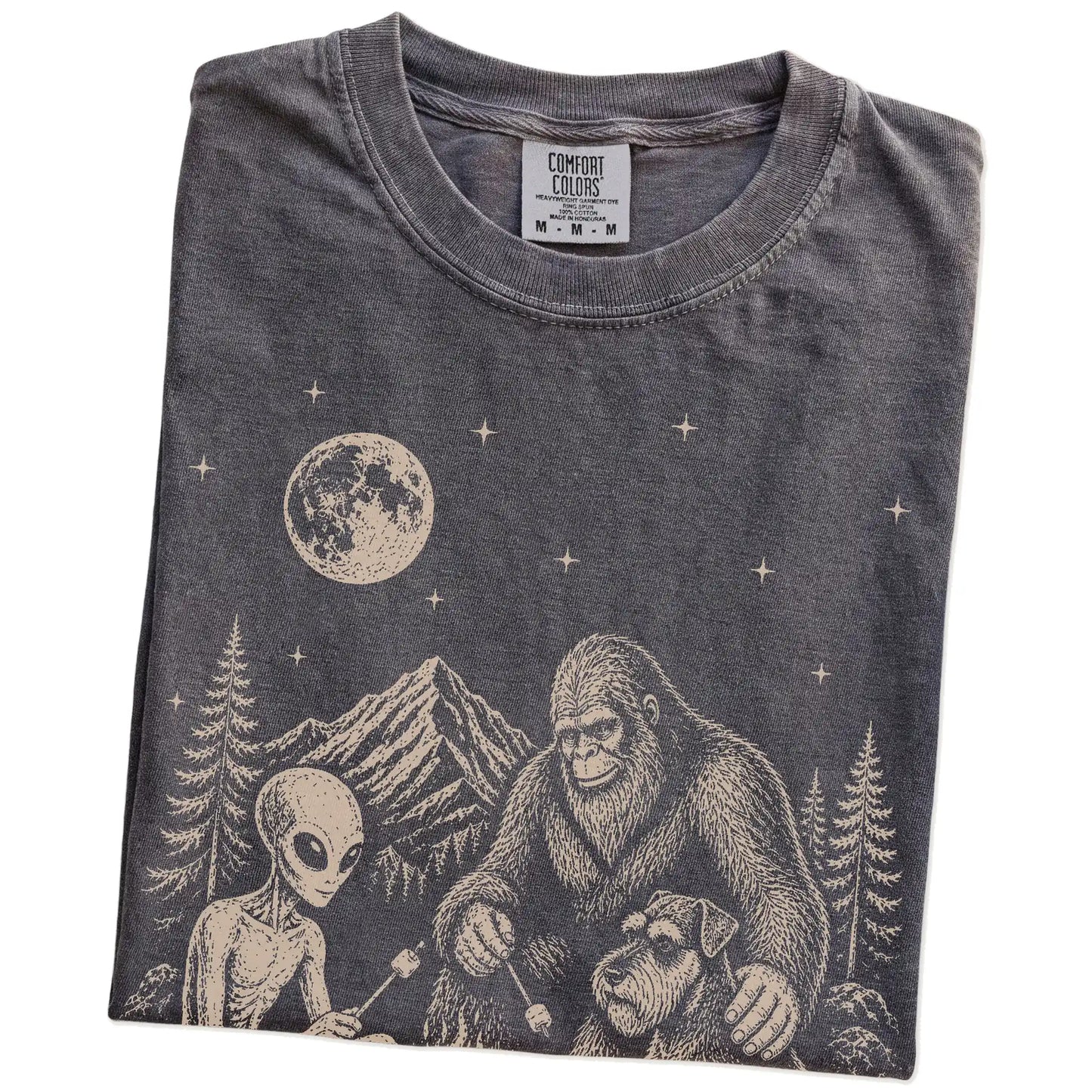 Folded Pepper Comfort Colors® T-shirt showing Standard Schnauzer camping with Bigfoot and an alien