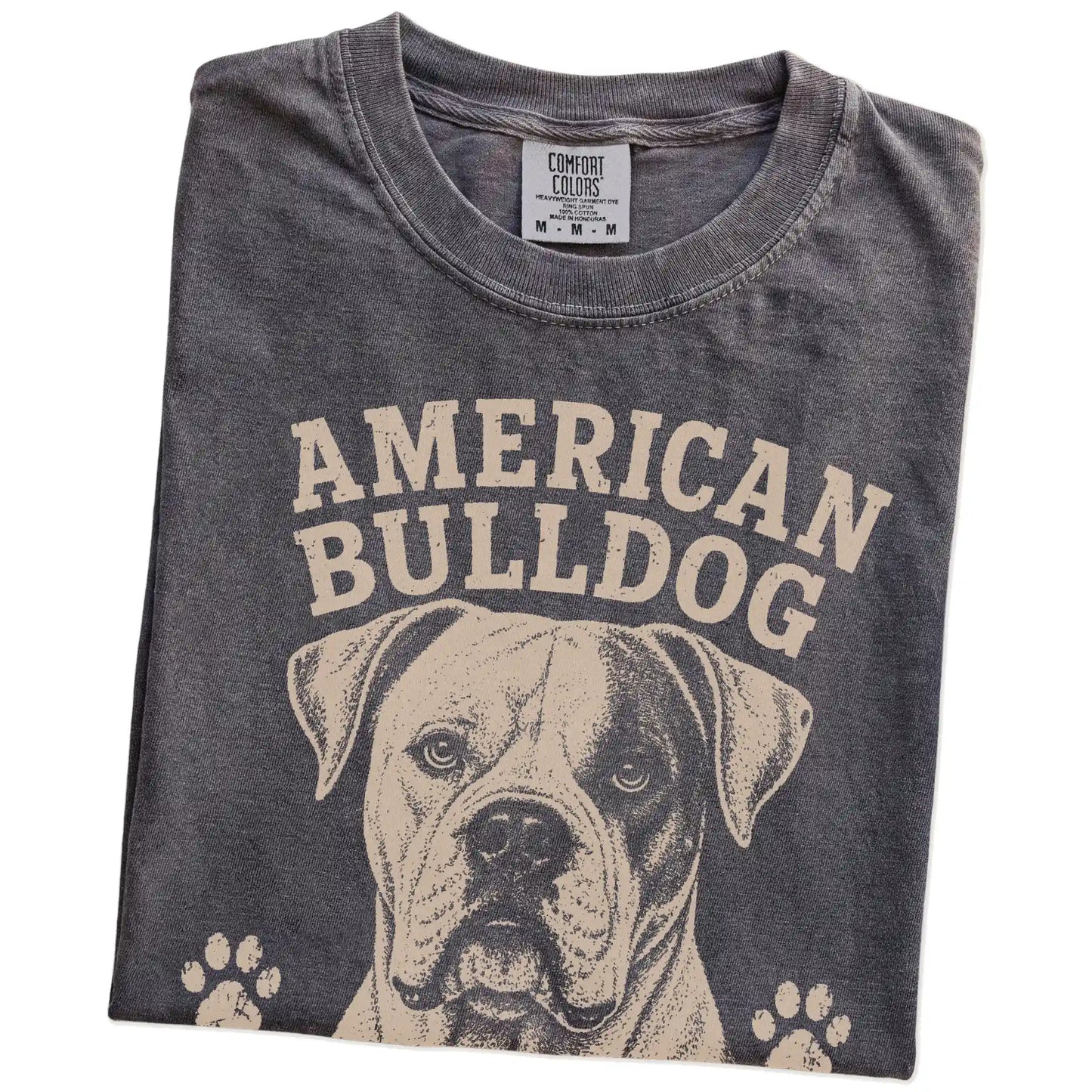 Folded Pepper Comfort Colors® T-shirt showing American Bulldog design with “Strong Opinions, Stronger Heart” lettering