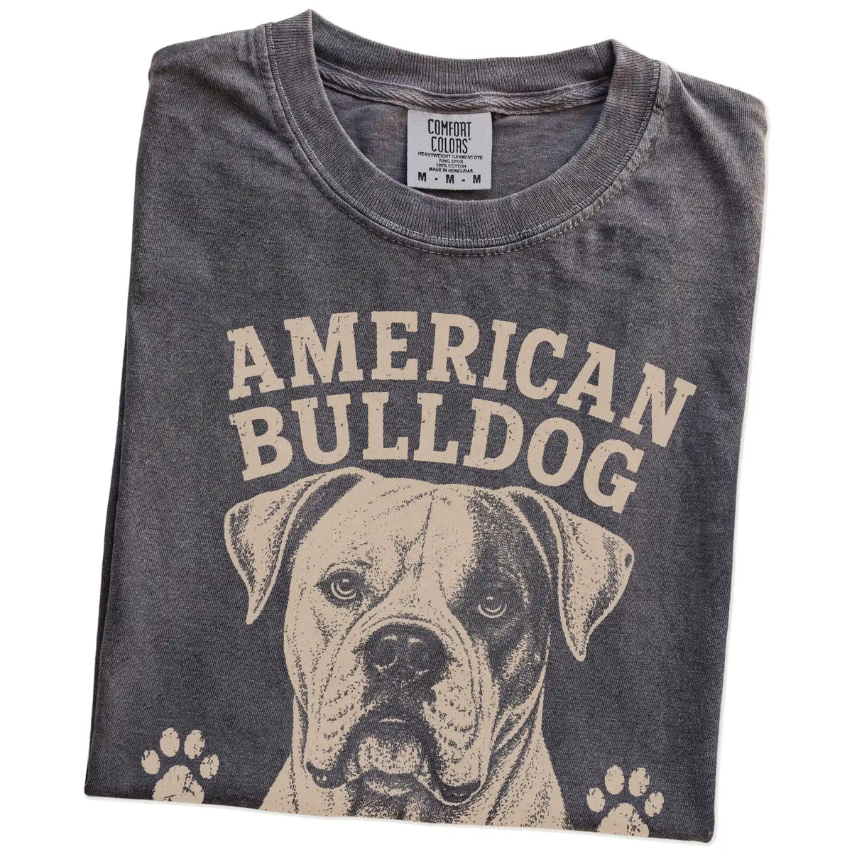 Folded Pepper Comfort Colors® T-shirt showing American Bulldog design with “Strong Opinions, Stronger Heart” lettering