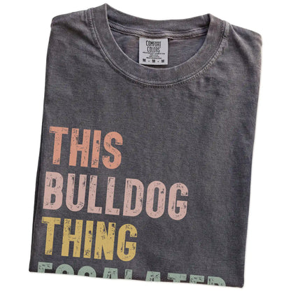Folded Pepper Comfort Colors® T-shirt showing retro “This Bulldog Thing Escalated Quickly” lettering