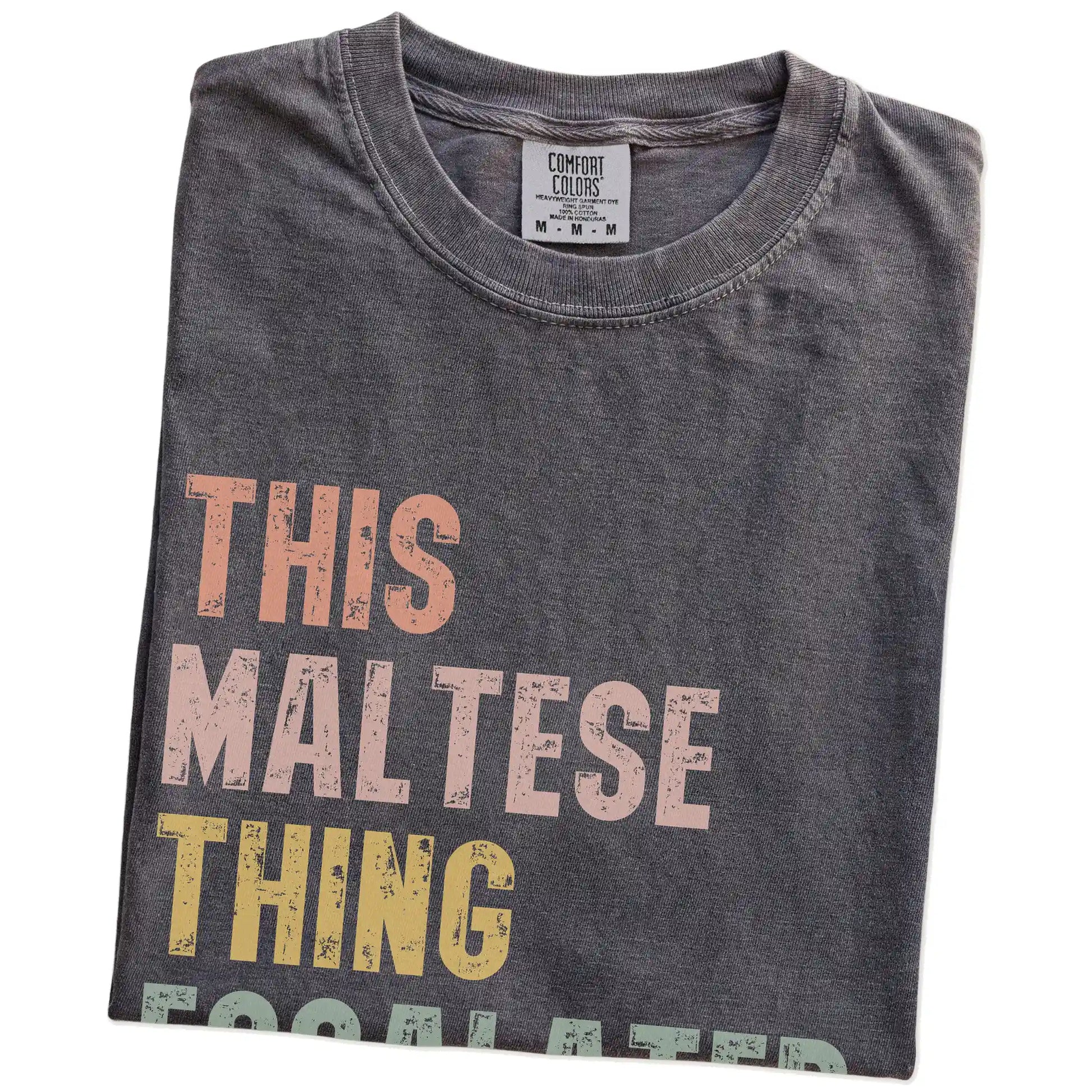 Folded Pepper Comfort Colors® T-shirt showing retro “This Maltese Thing Escalated Quickly” lettering