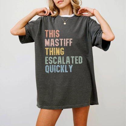 Model wearing a Pepper Comfort Colors® T-shirt with retro “This Mastiff Thing Escalated Quickly” lettering
