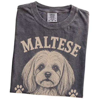Folded Pepper Comfort Colors® T-shirt showing Maltese design with “Tiny, Polished & Totally In Charge” lettering
